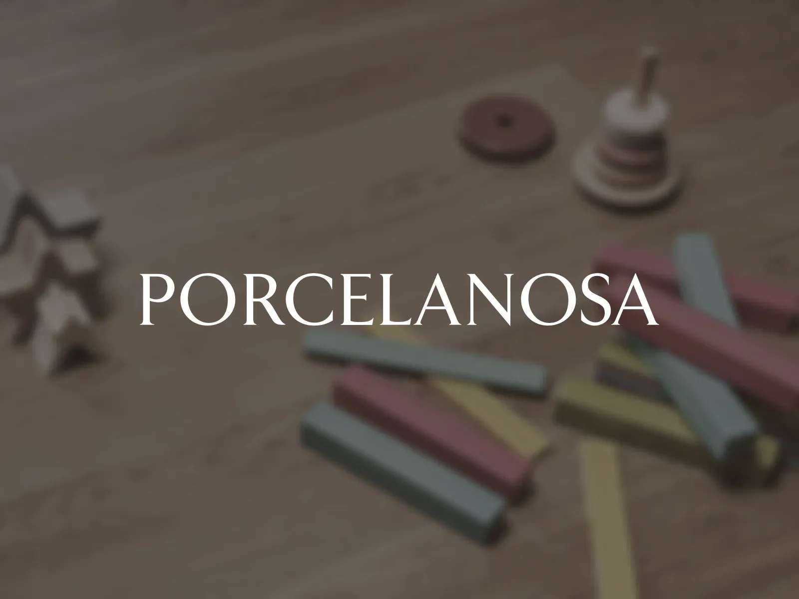 The Porcelanosa logo over toy blocks on a Porcelanosa wooden floor